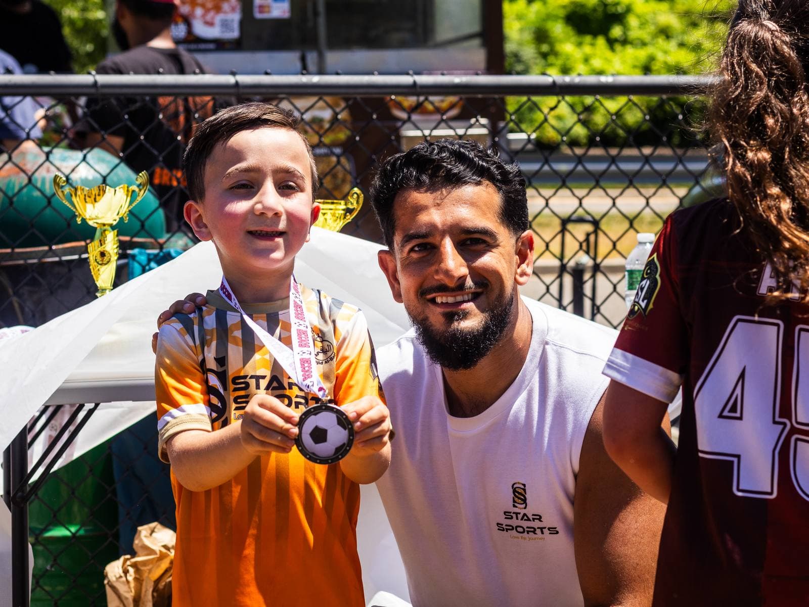 Founder Sanawullah Shairzai beside a young Star Sports player holding up his medal