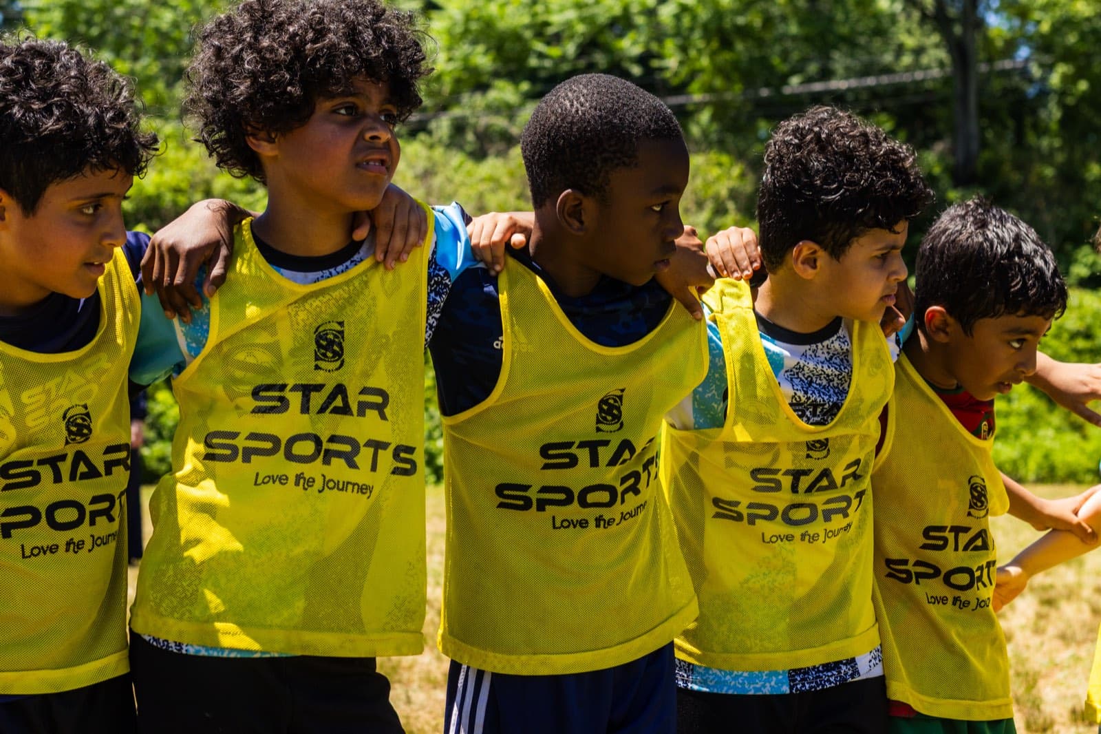 Players in yellow Star Sports pinnies huddle together